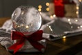 Christmas snow globe with knitting sweater on wooden table. Royalty Free Stock Photo