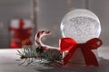 Christmas snow globe with red bow on table. Royalty Free Stock Photo