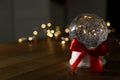 Christmas snow globe with red bow on wooden table. Royalty Free Stock Photo