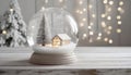 Christmas snow globe with a snow-covered Christmas tree and cottage inside, on a white wooden table Royalty Free Stock Photo