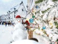 Christmas snow man in red santa hat and holiday trees decoration on street Tallinn Old town snowy weather travel to Estonia Euro