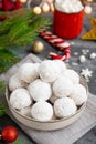 Christmas snowball cookies with walnuts and powdered sugar in a bowl on a gray concrete background with a cup of cocoa. Copy space Royalty Free Stock Photo