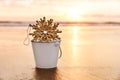 Christmas Snowflake in a White Bucket ar Sunset on the Beach in