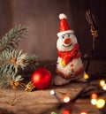 Christmas snowman decoration against the backdrop illumination and fir tree