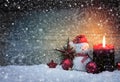 Christmas snowy background with fourth Advent candle and Snowman . Royalty Free Stock Photo