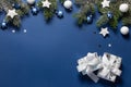 Christmas snowy border of gift box, shiny balls and stars, evergreen branches on blue background. New Year card Royalty Free Stock Photo