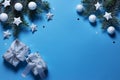 Christmas snowy border of gift box, shiny balls and stars, evergreen branches on blue background. New Year card Royalty Free Stock Photo