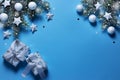 Christmas snowy border of gift box, shiny balls and stars, evergreen branches on blue background. New Year card Royalty Free Stock Photo