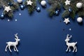 Christmas snowy border of shiny balls, stars and deer, evergreen branches on classic blue background Royalty Free Stock Photo