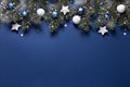 Christmas snowy border of shiny balls and stars, evergreen branches on classic blue background. New Year card Royalty Free Stock Photo