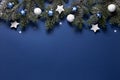 Christmas snowy border of shiny balls and stars, evergreen branches on classic blue background. New Year card Royalty Free Stock Photo