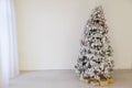 Christmas snowy Christmas tree with presents in a white room in winter Royalty Free Stock Photo