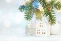 Christmas snowy background with green fir tree branch, star lights and decorative balls and house toys Royalty Free Stock Photo