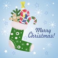 Christmas sock with gifts and sweets. Green sock with snowflakes ornament for home or fireplace decoration, for cards and holiday