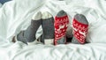 Christmas socks of family couple feet relaxing on bed having good sleep time together, enjoying resting at home in bedroom