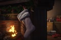 Christmas socks for New Year\'s gifts hang over a fireplace with fire. AI generated