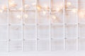 Christmas soft home decor with lights burning on a white wooden background. Royalty Free Stock Photo