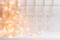 Christmas soft home decor with lights burning on a white wooden background. Royalty Free Stock Photo