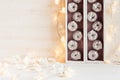 Christmas soft home decor of silver apples and lights burning in boxes on a wooden white background. Royalty Free Stock Photo