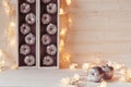 Christmas soft home decor of silver apples and lights burning in boxes on a wooden white background. Royalty Free Stock Photo