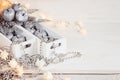 Christmas soft silver apples and lights burning in boxes on a wooden white background. Royalty Free Stock Photo