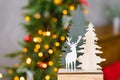 Christmas souvenir wooden Christmas trees and deer on the background of Christmas new year lights. Christmas holiday card