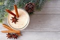 Christmas eggnog, top view with corner border of tree branches on gray wood Royalty Free Stock Photo