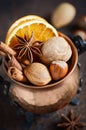 Christmas spices, nuts and dried oranges on a wooden background. Royalty Free Stock Photo