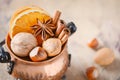 Christmas spices, nuts and dried oranges on a wooden background. Royalty Free Stock Photo