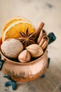 Christmas spices, nuts and dried oranges on a wooden background. Royalty Free Stock Photo