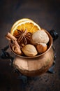 Christmas spices, nuts and dried oranges on a wooden background. Royalty Free Stock Photo
