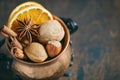 Christmas spices, nuts and dried oranges on a wooden background. Royalty Free Stock Photo