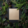 Christmas square card note between fir branches and pine cones on dark green background. Creative Xmas or New Year table layout.