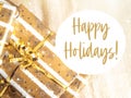 Christmas stack of golden wrapped gift boxes, text happy holidays Royalty Free Stock Photo