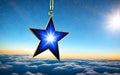 Christmas star hanging from a golden chain against a blue sky with clouds Royalty Free Stock Photo