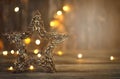 Christmas star with lights on a wooden background shine