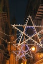 Christmas star lights and festive garlands decorating Orologio street with a view to Church of St. Ignatius at Olivella in Palermo Royalty Free Stock Photo