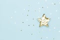 Christmas star made with mold for the cookies and gold sparkling stars on blue background. Flat lay Royalty Free Stock Photo