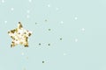 Christmas star made with mold for the cookies and gold sparkling stars on blue background. Flat lay. Holidays and Christmas Royalty Free Stock Photo