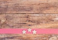 Christmas stars decoration on red ribbon border and wooden background Royalty Free Stock Photo