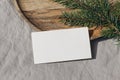 Christmas stationery. Closeup of blank business card, invitation mockup. Green spruce tree branch on wooden tray in