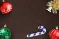 Christmas stick, red wavy and green ribbed ball, decorative bell on dark