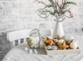 Christmas still life. Box of Christmas decorations, jar of marshmallows, alternative christmas tree on the white kitchen table