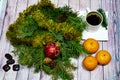 Christmas still life. branches of green spruce with ornaments, a Cup of coffee, three tangerines and candy on a light background