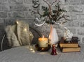 Christmas still life. Burning candle,stack of books, christmas tree, garland on the table Royalty Free Stock Photo