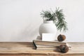 Christmas still life. Business card mockup on vintage wooden bench, table. Modern white ceramic vase with pine tree