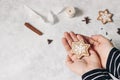 Christmas still life. Closeup of kids hands holding star gingerbread heart cookie with white icing. Grunge background Royalty Free Stock Photo