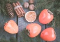 Christmas still life with persimmon and cinnamon with fir-tree on wooden background. Top view. Royalty Free Stock Photo