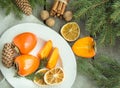 Christmas still life with fresh persimmon and cinnamon with pine tree on wooden background. Royalty Free Stock Photo