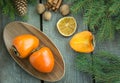 Christmas still life with fresh persimmon and cinnamon with pine tree on wooden background. Royalty Free Stock Photo